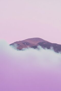 Majestic mountain ridges with rolling clouds in serene pastel sky