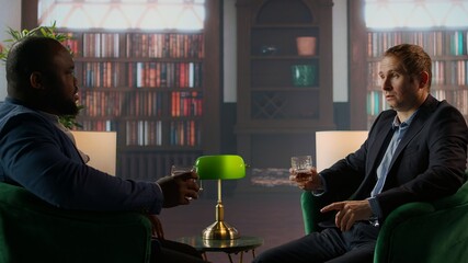 Gallant investor consultant engage in a meaningful conversation with a friend, enjoying a fine...