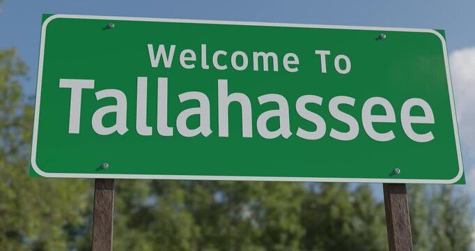 Driving By A Welcome To Tallahassee, Florida Green Road Sign Against a Blue Sky and Clouds - United States Capital Series.