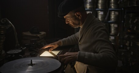 A Vintage Media Specialist working diligently in an Archive Setting focused on preserving old media
