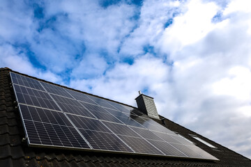 Photovoltaic panels producing renewable energy on a roof under a cloudy sky