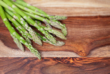Fresh green asparagus spears on a rustic wooden surface