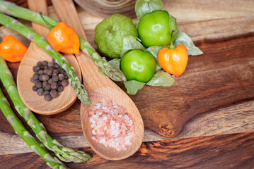 Assorted fresh vegetables and spices on a wooden background