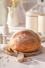 Tasty and homemade round loaf bread on cutting board.