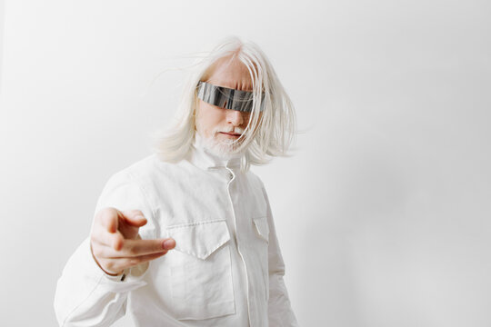 futuristic man with long white hair, wearing stylish sunglasses and a white outfit on a plain background, exuding a modern, tech savvy vibe and a confident pose