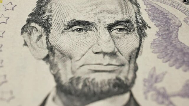 Portrait of 16th President Abraham Lincoln on USA five dollar bill. Economic strength. Detailed engraving captures historical significance of American leadership. Iconic image in financial history