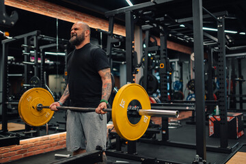 Determined bodybuilder lifting weights in modern gym