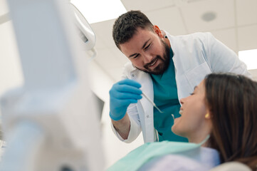 Obraz premium Dentist examining patient teeth with dental mirror and probe in dental clinic