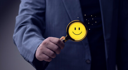 Customer satisfaction survey concept to gather insights and improve service. Magnifying glass focuses on smiling face.
