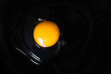 A raw egg on a black background
