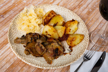 Rabbit liver dish with boiled potatoes and sauerkraut