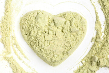 wasabi powder in heart shape on white background