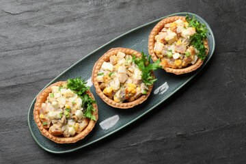Tartlets with delicious filling on black table, top view