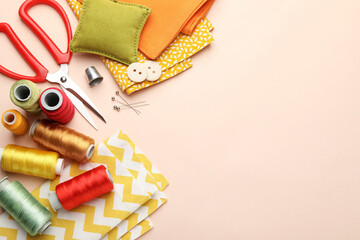 Obraz premium Different sewing supplies on light pink background, flat lay. Space for text