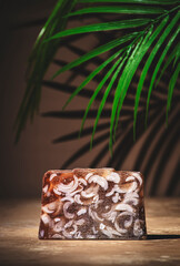 Handmade coffee soap with patterns on beige background. Hard light, leaves, shadows