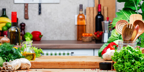 Healthy vegan eating, cooking, food blogging banner background. Empty oak cutting board with mushrooms, cabbage, lettuce, olive oil and wine on cozy kitchen with wooden table, kitchenware and utensils