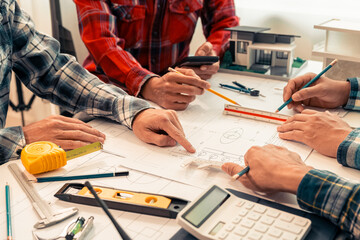 Close-up of industrial engineers team meeting to analyze machinery plans, discuss architectural projects, review construction plans and building plans using tablets at conference table.
