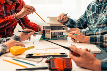 Close-up of industrial engineers team meeting to analyze machinery plans, discuss architectural projects, review construction plans and building plans using tablets at conference table.
