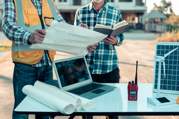 Close-up of industrial engineers team meeting to analyze machinery plans, discuss architectural projects, review construction plans and building plans using tablets at conference table.