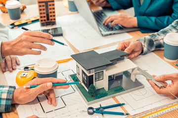Close-up of industrial engineers team meeting to analyze machinery plans, discuss architectural projects, review construction plans and building plans using tablets at conference table.