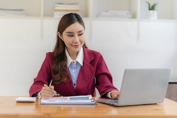 Beautiful business Asian woman with suit working at office table using laptop computer with copy space. Businessman, freelance employee, online marketing