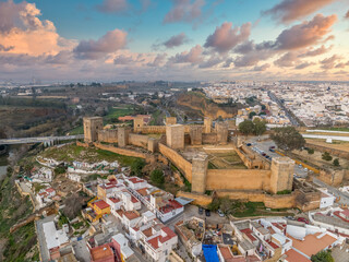 Alcalá de Guadaíra Castle: A Study in Moorish & Gothic Design, square towers, battlements sunset cloudy sky