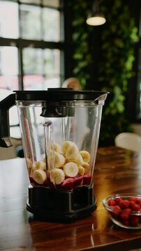 Fresh smoothie preparation: bananas and berries blended in rustic cafe setting