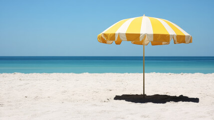Bright yellow beach umbrella on sandy shore with calm ocean waves