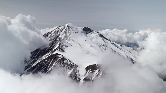 Winter mountains in clouds and bursts of steam from fumaroles