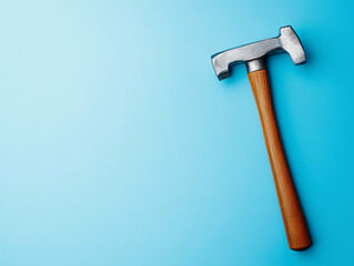 Hammer tool wooden handle metal head isolated blue background construction equipment hardware object sturdy durable industrial work carpentry maintenance repair craftsmanship simple design iron steel