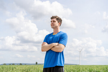 Fototapeta premium Portrait of Caucasian sportsman exercise at the wind turbine field. 