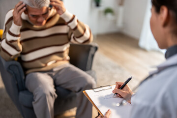 Close up of Asian caregiver nurse examine and listen to senior patient. 