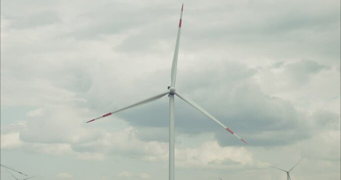 Wind turbine rotating under cloudy sky