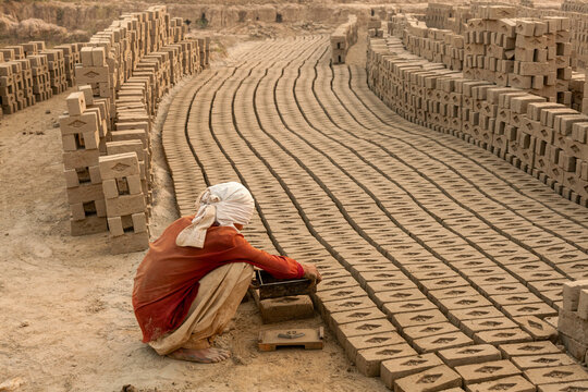 Brick maker.
A unknown boy making mud bricks