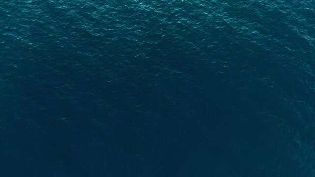 Calm, deep blue ocean waters, possibly taken off the coast of italy, aerial view