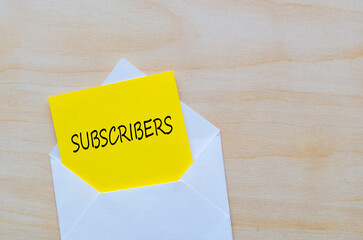 Subscribers text on yellow notepad inside a white envelope. Making money online concept