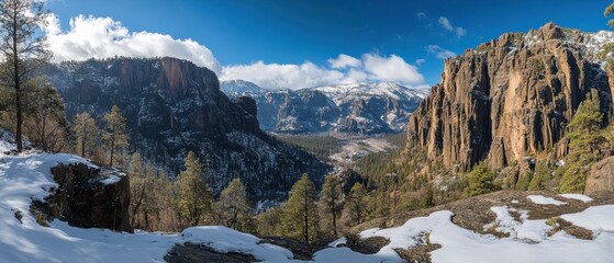 Majestic mountain vista of snowy peaks and rugged cliffs under a bright blue sky in winter landscape of nature scenic view