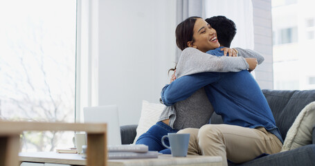 Fototapeta premium Love, hug and couple in home, laptop and chilling in living room with woman, embrace and coffee in morning. Happy, man and romance with partner in lounge, freelancer and excited for job opportunity