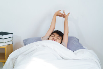 Asian little boy wakes up in morning.