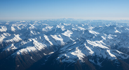 Obraz premium Snowy Mountain Peaks Stretching to Horizon on Clear Day Aerial View