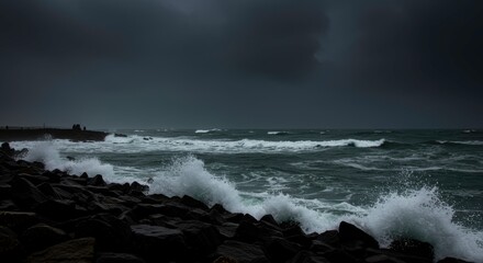 Obraz premium Dramatic Ocean Waves Crashing on Rocky Shore Under Dark Stormy Sky
