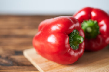 Red bell peppers on a wooden cutting board. Selective focus.