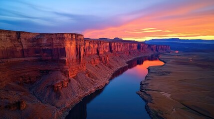 Fototapeta premium Mountain range landscapes idea. Vibrant sunset over majestic cliffs reflecting in tranquil river waters.