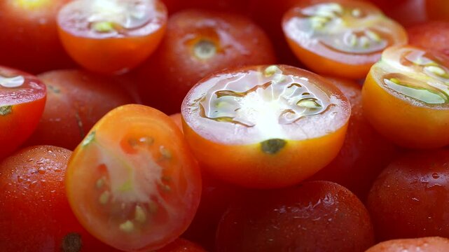 Cherry tomatoes whole and half cut kept on rotating disc. Close up video of cherry tomatoes