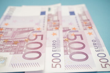 Euro banknotes are spread out on the table.