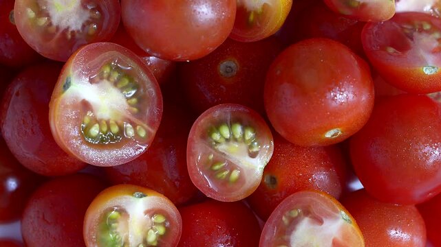 Cherry tomatoes whole and half cut kept on rotating disc. Close up video of cherry tomatoes