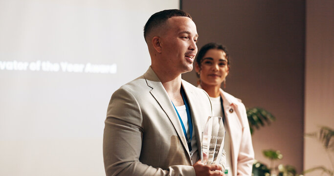 Business, man or speech in award ceremony for trophy, achievement or winning at seminar. Man, presentation or comment with smile for accomplishment, milestone or employee of month at workshop