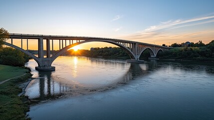 Fototapeta premium Scenic Sunset Over a Majestic Bridge with Reflections in Calm Water Under a Clear Sky Creating a Peaceful Atmosphere for Nature Lovers and Travelers