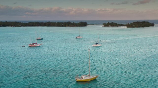 Serene turquoise waters enveloping lush tropical island, pristine sailboats anchored offshore, showcasing tranquil paradise with breathtaking scenic beauty of south pacific landscape