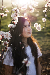 Fototapeta premium long-haired teen girl portraits in a blooming cherry garden